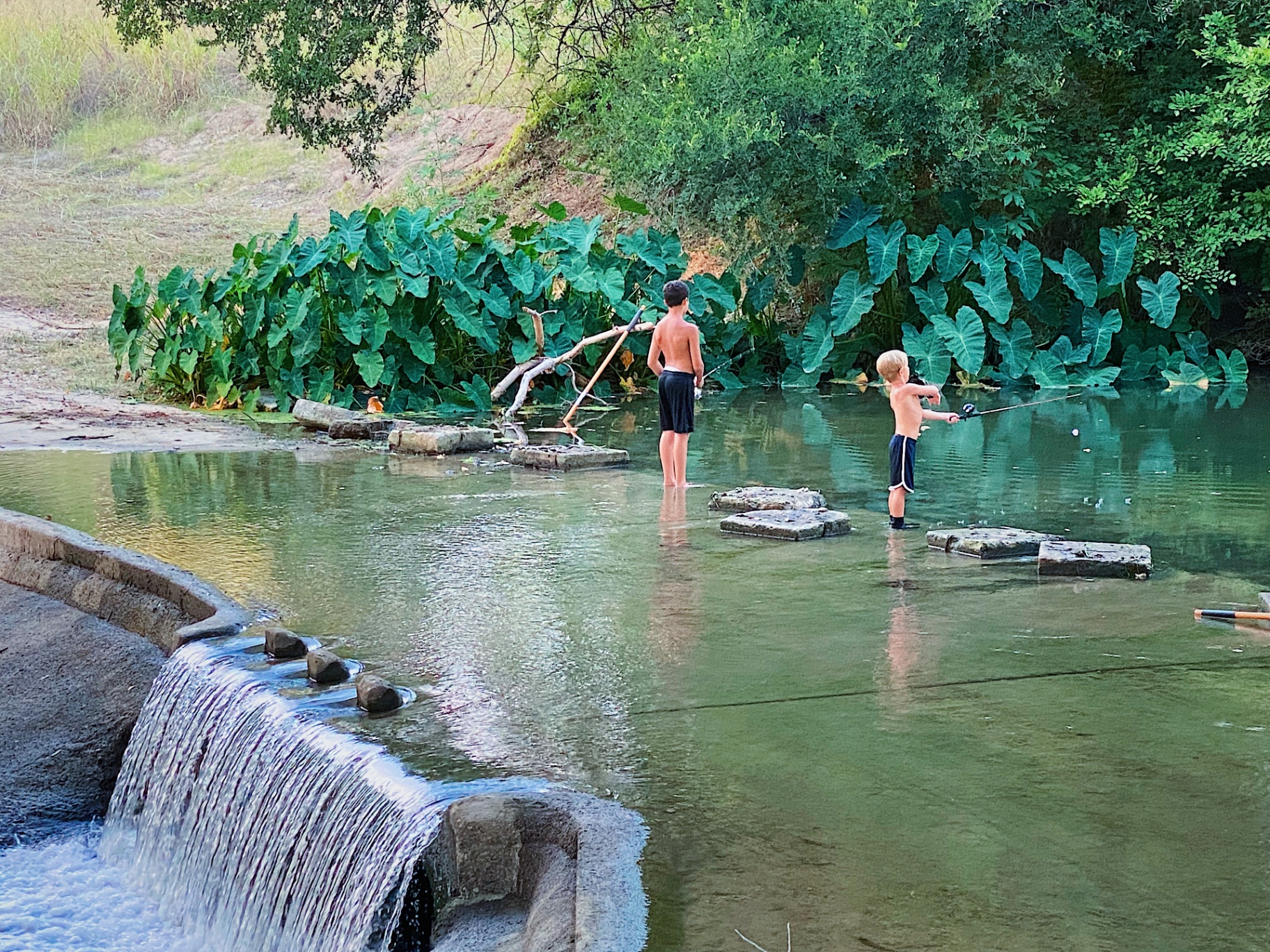 Boys playing at the waterfall