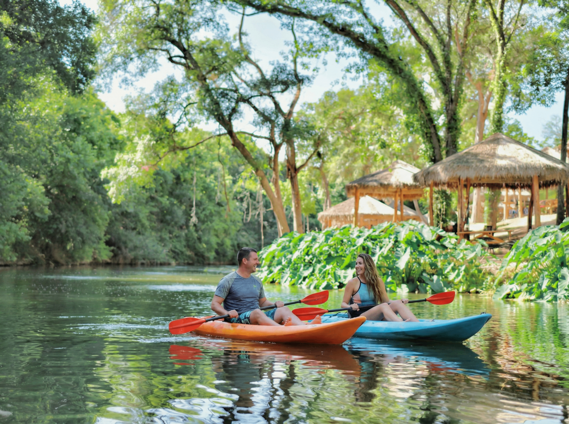 Couple relaxing in hammock by the creek