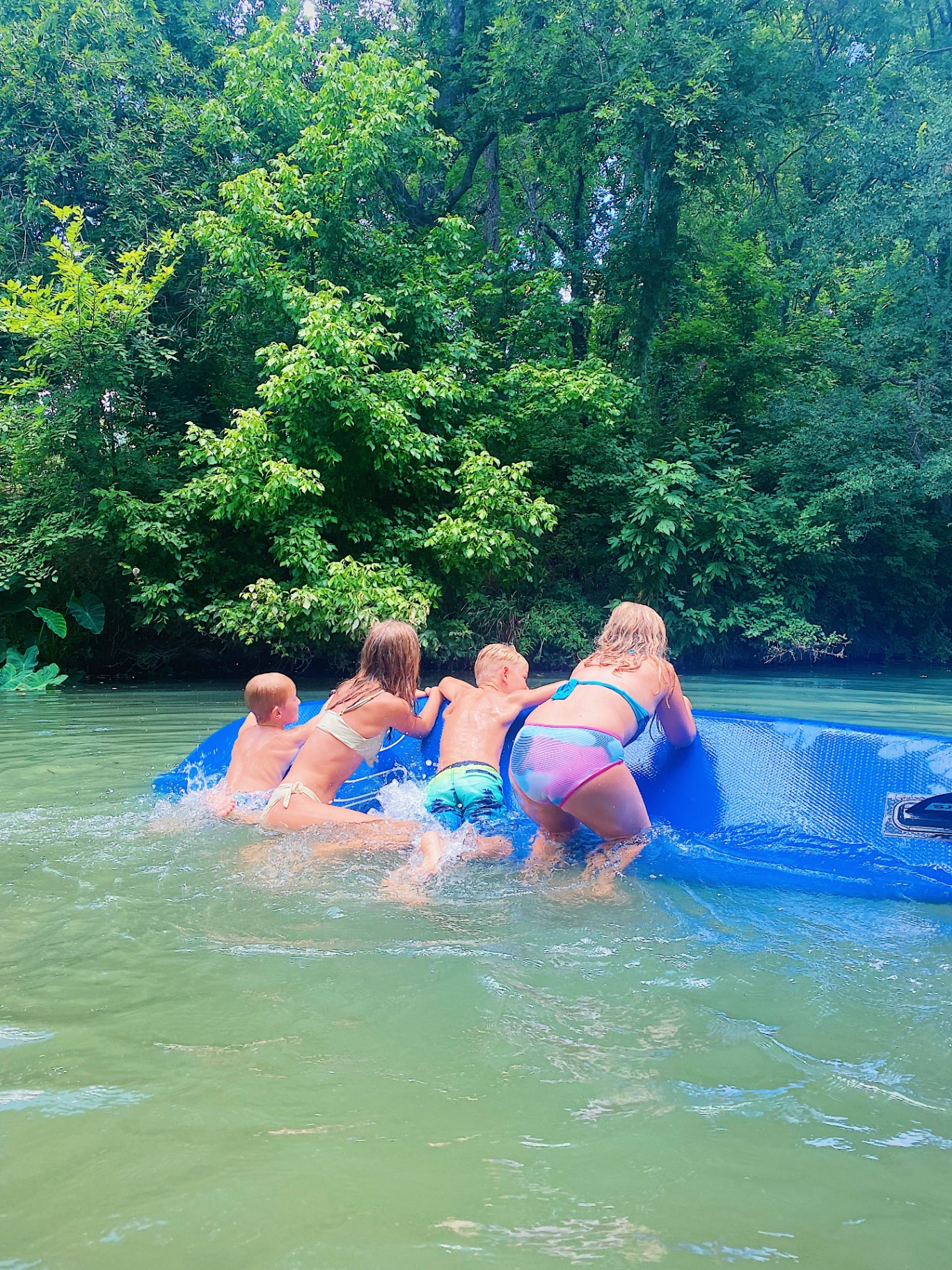 Kids playing on paddleboard in the creek
