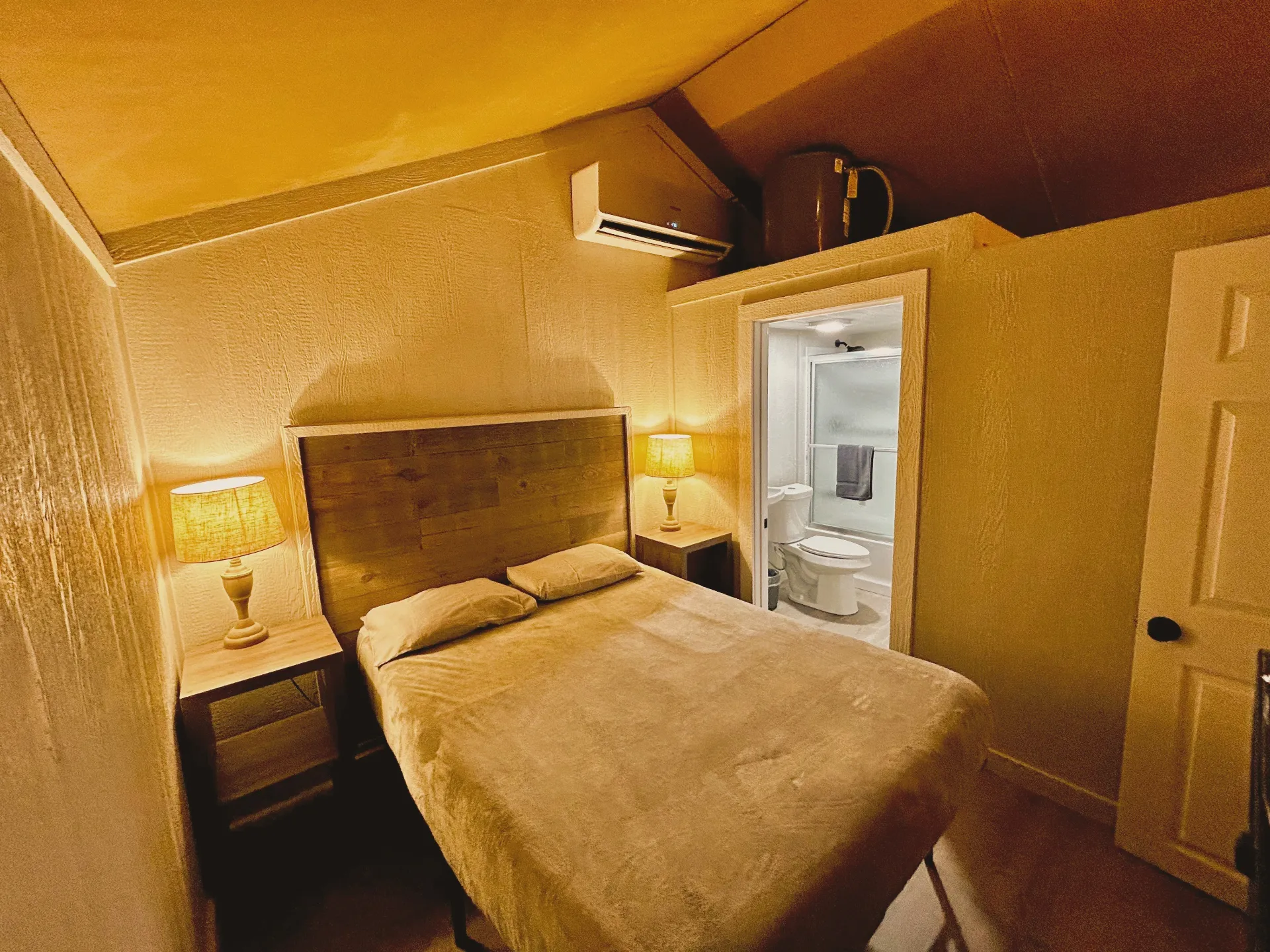 Safari Cabin bedroom with queen bed and bathroom view